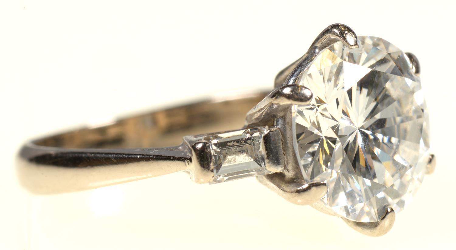 A DIAMOND  RING   the round brilliant cut diamond of approx 3.2cts flanked by a baguette diamond - Image 3 of 7