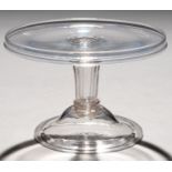 AN ENGLISH GLASS SALVER, MID 18TH C on moulded stem and domed and folded foot, 21cm diam Good