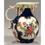 A WORCESTER SCALE BLUE GROUND CABBAGE LEAF MASK JUG, C1770 painted in bright enamels with flowers