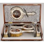 A GEORGE V INLAID TORTOISESHELL INSET SILVER BRUSH SET  embossed with festoons and inlaid in