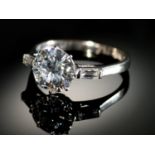 A DIAMOND RING  the round brilliant cut diamond of approx 2cts flanked by a baguette diamond to each