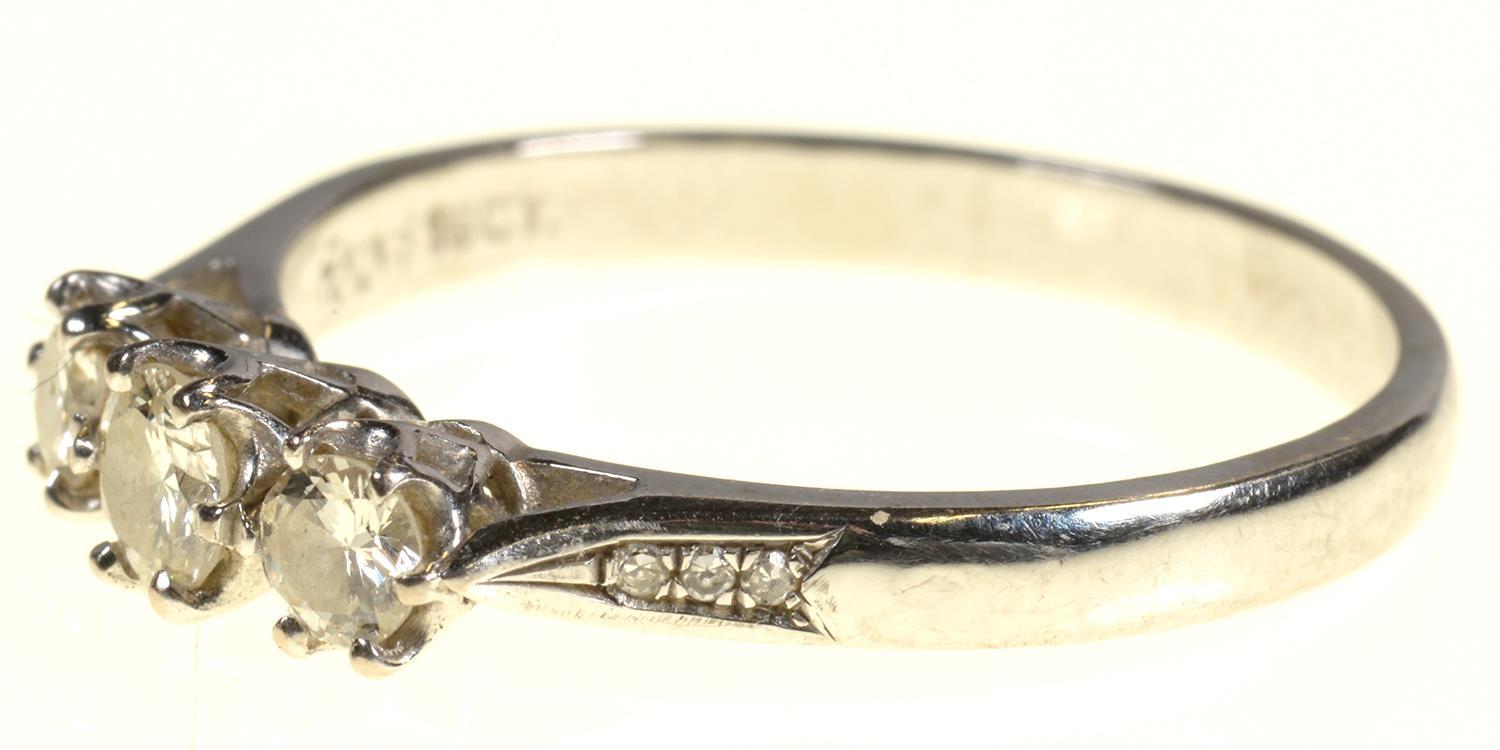 A DIAMOND THREE STONE RING with round brilliant cut diamonds and diamond set shoulders, in 18ct - Image 7 of 7