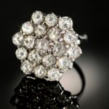 A DIAMOND CLUSTER RING  of nineteen evenly sized round brilliant cut diamonds arranged in an