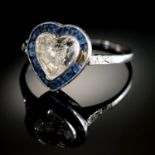 A HEART SHAPED DIAMOND AND SAPPHIRE CLUSTER RING with surround of calibre cut sapphires and