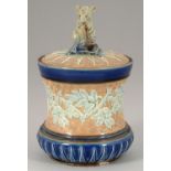ATTRIBUTED TO GEORGE TINWORTH.  A DOULTON WARE TOBACCO JAR AND COVER, 1900 of spool shape, the cover