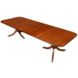 A MAHOGANY DINING TABLE, SECOND QUARTER 20TH C   with two leaves, on two triple leg pillars and