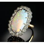 AN OPAL AND DIAMOND RING  the 10 x 19mm oval opal of fine polish, in gold marked 18ct, 7.8g, size