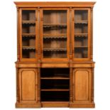 A VICTORIAN LIGHT OAK AND EBONISED BOOKCASE, C1870  with leaf carved and fluted pilasters, the upper
