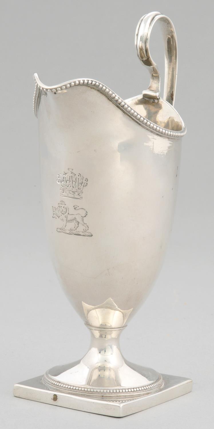 A GEORGE III HELMET SHAPED SILVER CREAM JUG with beaded rims, crested, 16.5cm h, by Robert