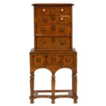 A WALNUT AND GEOMETRIC INLAID CHEST ON STAND  incorporating earlier veneers,  the stand with