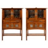 A PAIR OF GLASGOW STYLE OAK CABINETS LATE 20TH C the pair of leaded glass doors with carved reserves