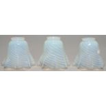 A SET OF THREE SPIRALLY REEDED SEMI-OPALESCENT GLASS EARLY ELECTRIC LAMPSHADES, EARLY 20TH C, BELL