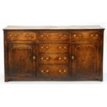 A GEORGE III OAK DRESSER, EARLY 19TH C, WITH MOULDED TOP AND BRASS FURNITURE, ON TILES   85CM H; 166