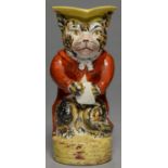 A STAFFORDSHIRE EARTHENWARE ANTHROPOMORPHIC CAT JUG, C1870, THE TABBY CAT CLOTHED IN A