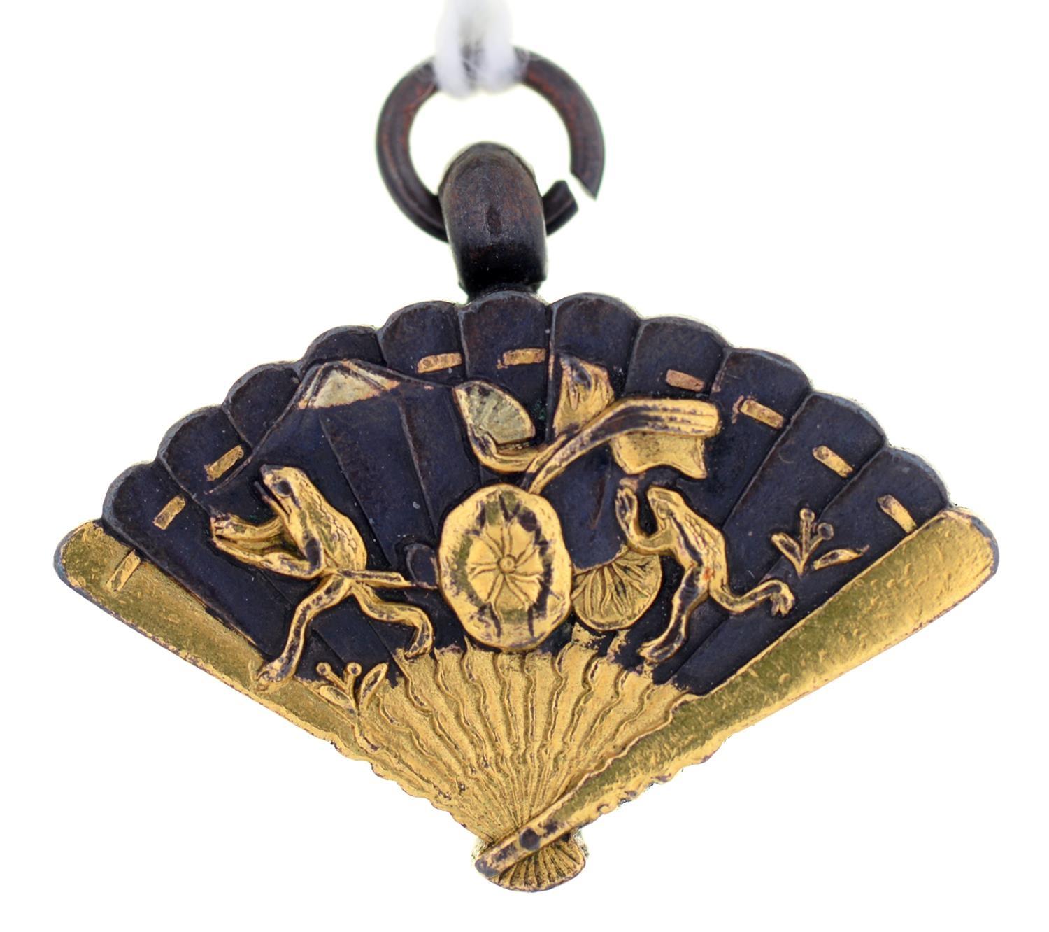 A JAPANESE SHIBUICHI AND GOLD FAN SHAPED FOB PENDANT, THE BACK INSET WITH A COMPASS, MEIJI PERIOD,