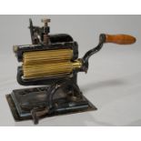 THE ?CROWN?. A NORTH AMERICAN BRASS AND BLACK PAINTED CAST IRON FLUTING/CRIMPING MACHINE, ON