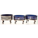ONE AND A PAIR OF GEORGE III PIERCED OVAL SILVER SALT CELLARS, ON CLAW AND BALL FEET, BLUE GLASS