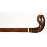 AN ART DECO EXOTIC HARDWOOD AND IVORY WALKING CANE, THE BULBOUS HANDLE INLAID WITH SILVER ZIG ZAG