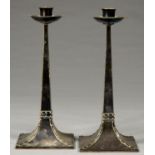 A PAIR OF ARTS AND CRAFTS EPNS CANDLESTICKS, C.1900, ON FLARED SQUARE BASE, 31CM H Condition report