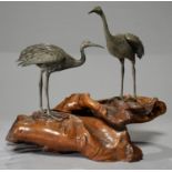 A PAIR OF JAPANESE SILVERED METAL MODELS OF CRANES, MEIJI PERIOD, ON WELL PATINATED ROOTWOOD