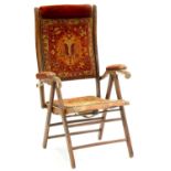 A VICTORIAN BEECH AND IRON FOLDING OR CAMPAIGN CHAIR, IN THE ORIGINAL CLOSE NAILED PADDED VELVET AND