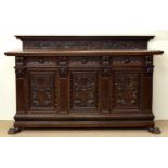 A PROFUSELY CARVED STAINED WALNUT BUFFET, RETAINING THE CORNICE OF THE SUPERSTRUCTURE, FITTED WITH