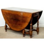 AN OAK GATELEG TABLE, EARLY 20TH C, IN CHARLES II STYLE, THE ROUND TOP ON BALUSTER LEGS UNITED BY