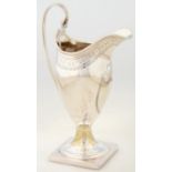 A GEORGE III HELMET SHAPED SILVER CREAM JUG, WITH ENGRAVED BORDER, REEDED HANDLE AND SQUARE FOOT,