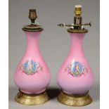 A PAIR OF FRENCH GILT BRASS MOUNTED PORCELAIN OIL LAMPS, THE BALUSTER VASE PRINTED AND PAINTED