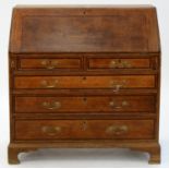 A GEORGE III OAK AND CROSSBANDED BUREAU, EARLY 19TH C, INLAID WITH MAHOGANY, ON BRACKET FEET,