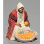 A ROYAL DOULTON BONE CHINA FIGURE OF AN ORANGE VENDOR, 1930, MODELLED BY C J NOKE AND DECORATED IN