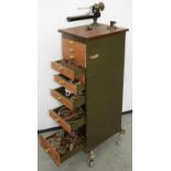 AN 8MM LATHE, ON WOOD BASEBOARD, 34 X 41CM, MOUNTED ON A METAL CHEST OF DRAWERS CONTAINING