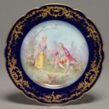 A SEVRES STYLE COBALT GROUND PLATE, C1900, PAINTED WITH 18TH C LOVERS, INDISTINCTLY SIGNED, IN