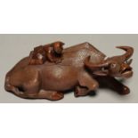 A JAPANESE ROOTWOOD CARVING OF A BOY ON A RECUMBENT BUFFALO, EARLY 20TH C, THE ANIMAL WITH GLASS