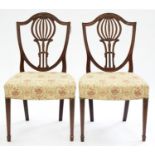 A PAIR OF GEORGE III CARVED MAHOGANY SHIELD BACK DINING CHAIRS, ON SQUARE TAPERING LEGS Condition