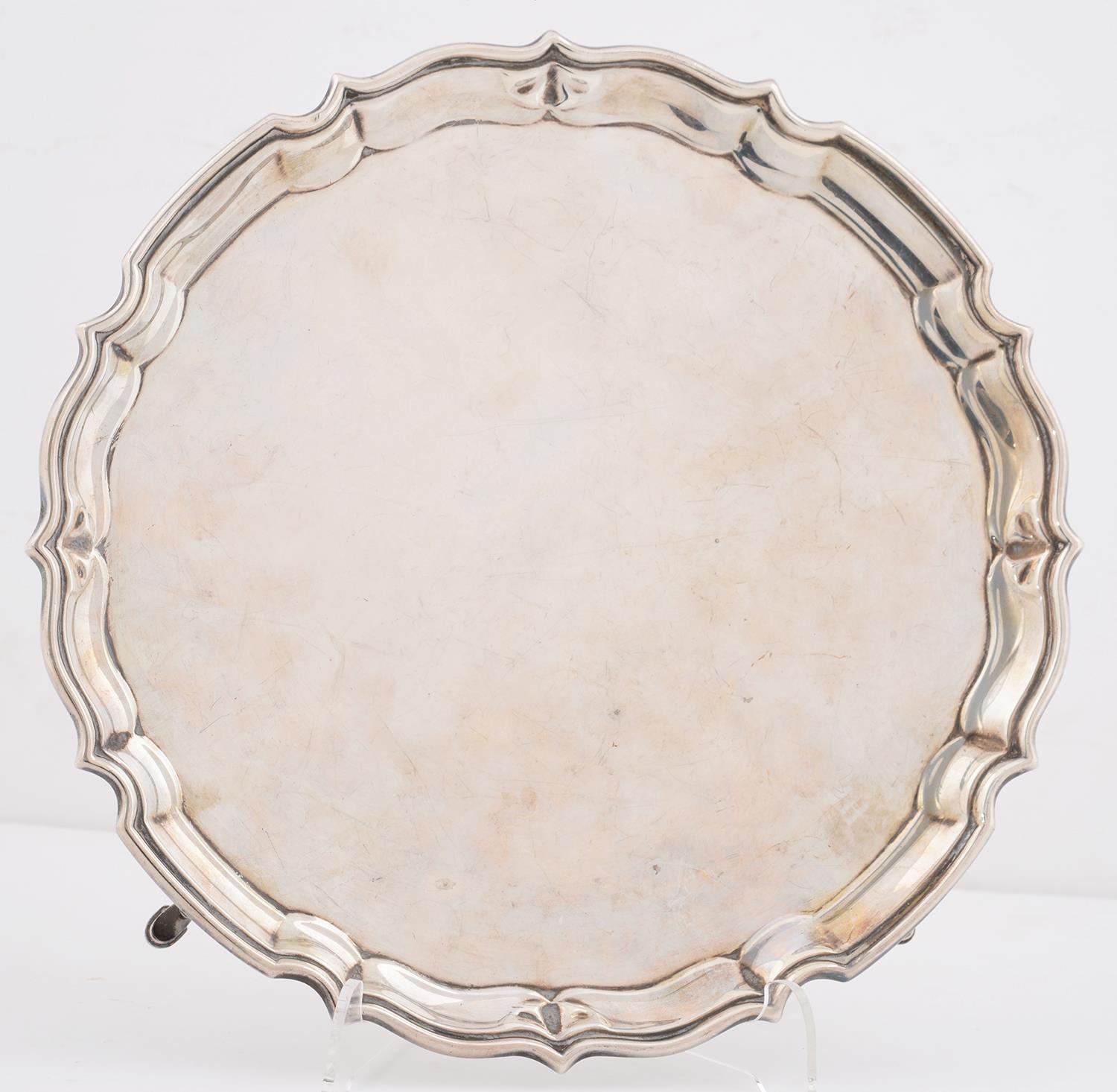 A GEORGE V SILVER SALVER, WITH MOULDED RIM, ON FOUR HOOF FEET, 26CM DIAM, BY BARKER BROS LTD,