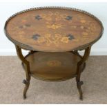 AN EDWARDIAN OVAL MAHOGANY AND MARQUETRY ETAGERE, C1905, THE TOP DECORATED WITH A MUSICAL TROPHY,