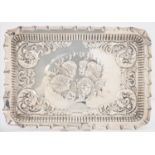 AN EDWARDIAN SILVER DRESSING TABLE TRAY, DIE STAMPED WITH CHERUB'S HEADS AND SCROLLING SPANDRELS