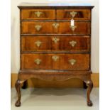 A WALNUT CHEST ON STAND, C1710, THE TOP WITH MOULDED CORNICE ABOVE TWO SHORT AND THREE GRADUATED,