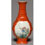 A CHINESE CORAL GROUND FAMILLE ROSE VASE OF BALUSTER SHAPE AND BAMBOO-MOULDED, PAINTED WITH A