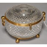 A GILTMETAL MOUNTED CUT GLASS CASKET, C1890, WITH RING HANDLES, ON BALL FEET, 14CM DIAM Good