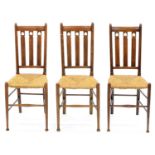 A SET OF THREE ARTS AND CRAFTS RUSH SEATED BEECH DINING CHAIRS, EARLY 20TH C, SEAT HEIGHT 45CM