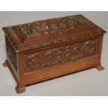 AN EDWARDIAN CARVED WALNUT CASKET AND COVER, C1900, DECORATED WITH FOLIAGE AND STRAPWORK, 39CM L