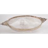 A VICTORIAN OVAL SILVER MOUNTED CUT GLASS BOWL, WITH CAST OPENWORK CHERUBS AND MASK HANDLES, 29CM