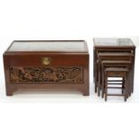 A CHINESE CARVED CAMPHOR WOOD TRUNK ON BRACKET FEET, 60CM H; 103 X 53CM AND A NEST OF FOUR TABLES EN