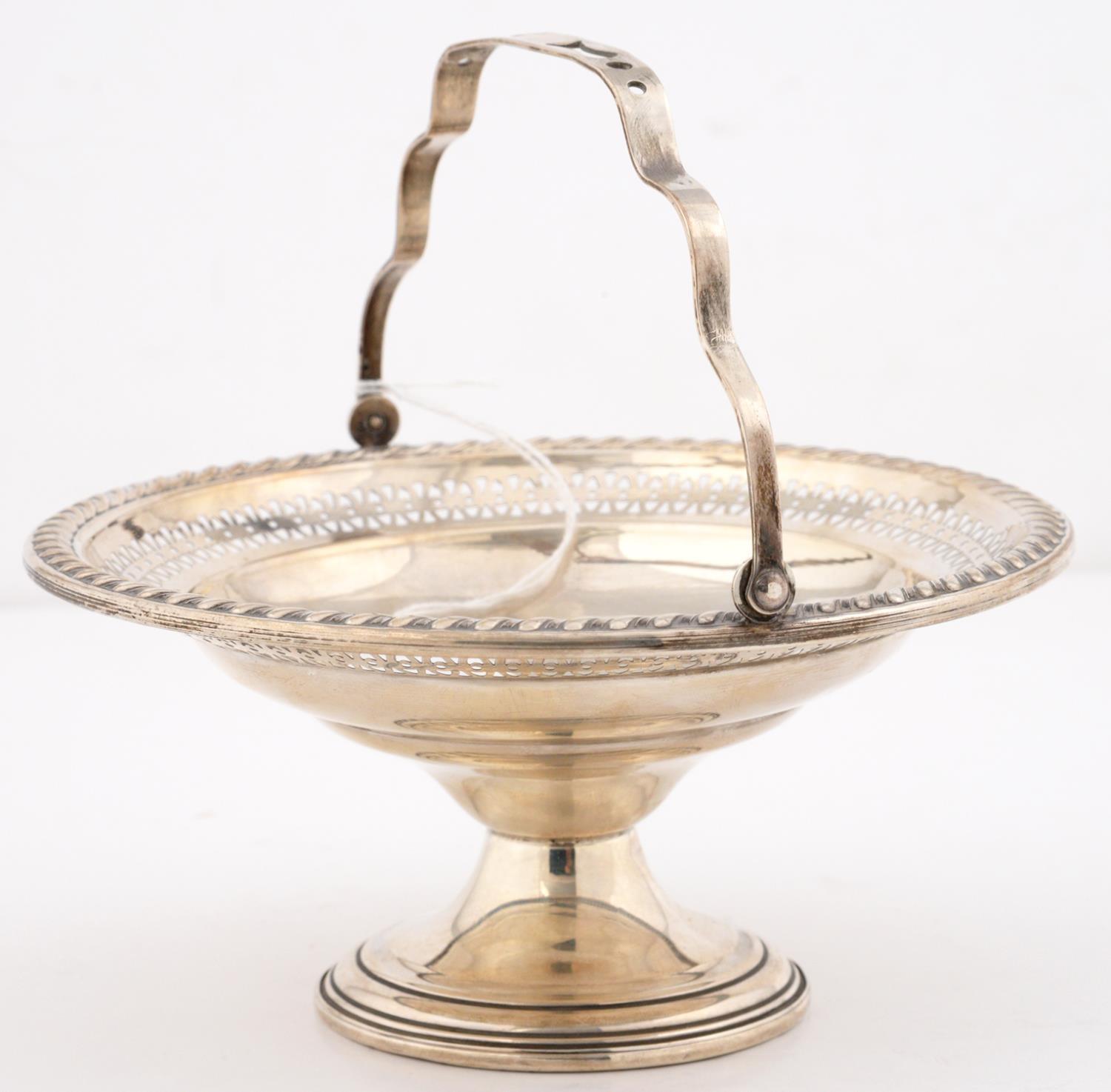 A NORTH AMERICAN PIERCED SILVER BASKET, EARLY 20TH C, WITH SWING HANDLE AND GADROONED RIM, 15CM