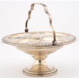 A NORTH AMERICAN PIERCED SILVER BASKET, EARLY 20TH C, WITH SWING HANDLE AND GADROONED RIM, 15CM