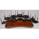 TEN EBONISED WOOD CUP AND SAUCER STANDS AND A DAMAGED EDWARDIAN INLAID MAHOGANY GALLERY TRAY