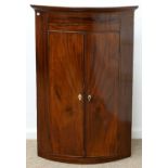 A GEORGE III BOW FRONTED MAHOGANY AND LINE INLAID HANGING CORNER CUPBOARD, EARLY 19TH C, THE PAINTED