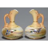 A PAIR OF ROYAL WORCESTER EWERS, PAINTED ON THE COMPRESSED BODY BY JAS STINTON, BOTH SIGNED, WITH